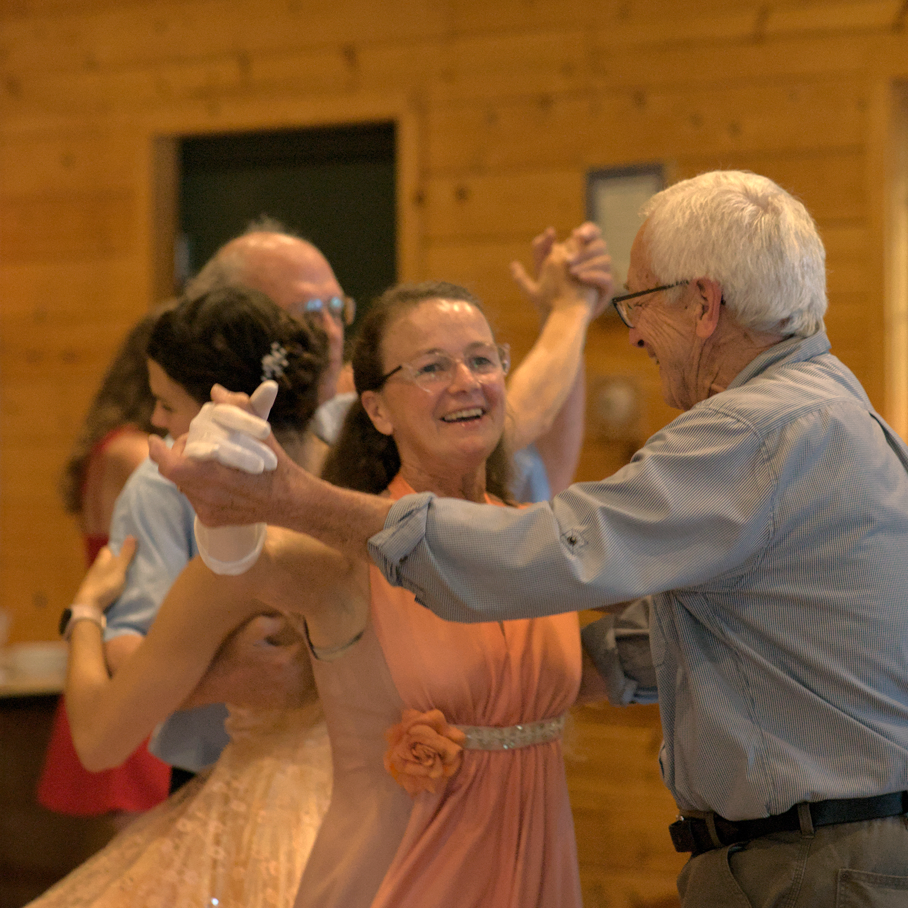 woman in a pink dress and white gloves dancing a waltz with an older man