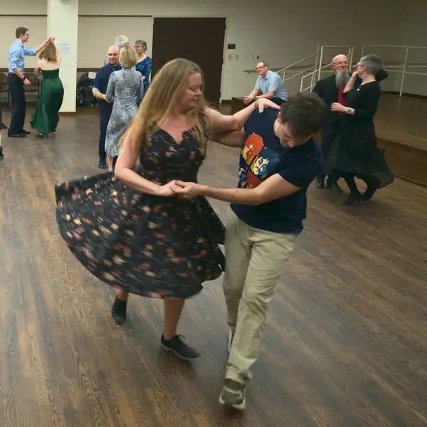 two people dancing partner salsa, the woman's skirt flared out